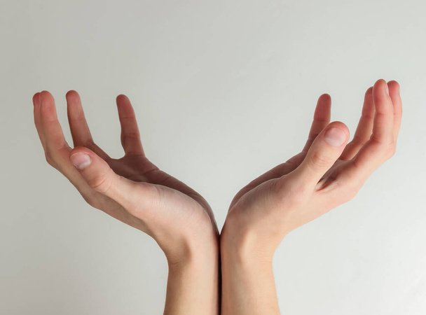 As mãos femininas formam um espaço para o seu texto sobre um fundo branco. Espaço de cópia - Foto, Imagem