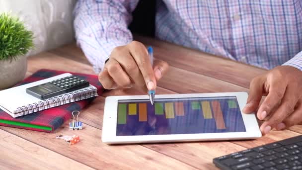 podnikatel analyzuje grafy na digitálním tabletu na kancelářském stole  - Záběry, video