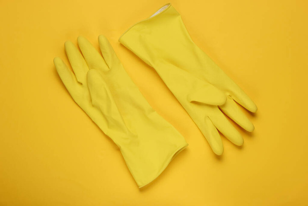 Latex gloves for cleaning on a yellow background. The concept of cleaning. Studio shot. Top view - Photo, Image
