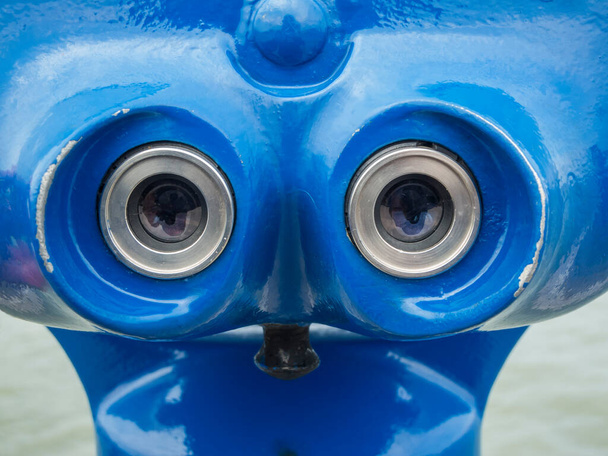 Zbliżenie okularów na niebieskiej lornetce stereo używanej przez turystów. - Zdjęcie, obraz