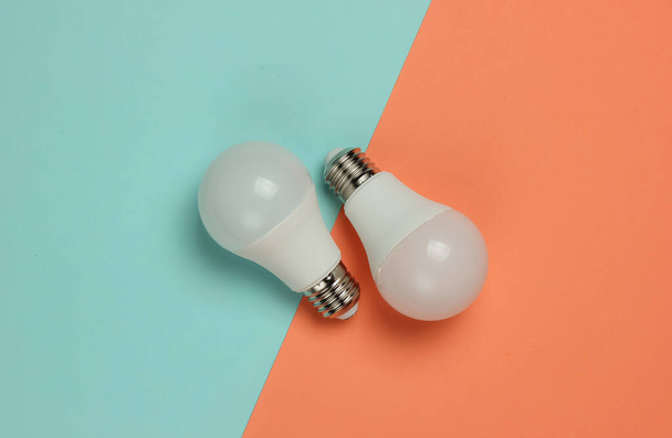 Three LED light bulbs on pink blue background. Top view - Foto, Imagem