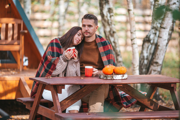 Młoda para z kawą na podwórku domu jesienią - Zdjęcie, obraz