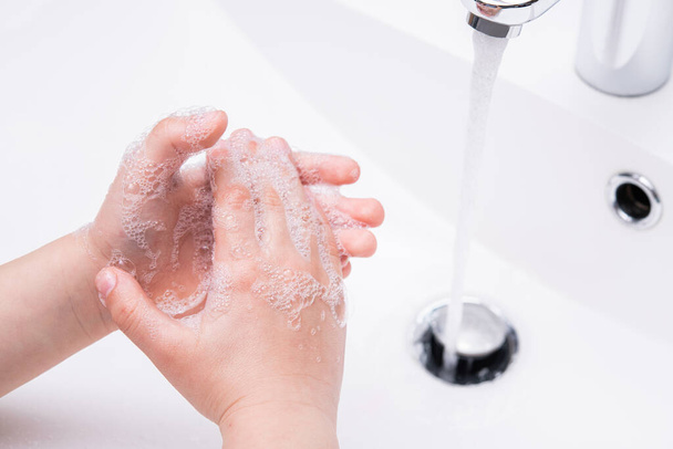 Kind wäscht sich im Badezimmer die Hände mit Seife. Prävention und Schutz der Coronavirus-Pandemie. Hygienekonzept. - Foto, Bild