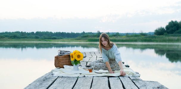 Mutlu Kız, gölde sabah güneşinde iskelede kahvaltı hazırla. Sıcak Çay, Çaydanlık ve Tatlılar Mutluluk veya İlham Konsepti, Hayatın Tadını çıkar - Fotoğraf, Görsel
