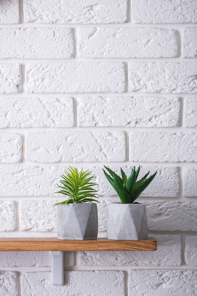 Scandinavisch interieur. Baksteen witte muur met houten plank en groene vetplanten. - Foto, afbeelding