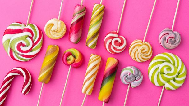 Lollypops trend food on a pink background. Pop Art. Top view. Summer bright sweets. Flat Lay. Wide format panorama. - Photo, Image
