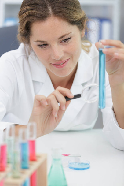 female laboratory assistant with chemical experiment in scientific laboratory - Photo, image