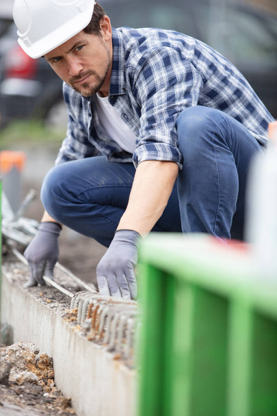 male construction worker aligning reinforcement bars - Фото, зображення