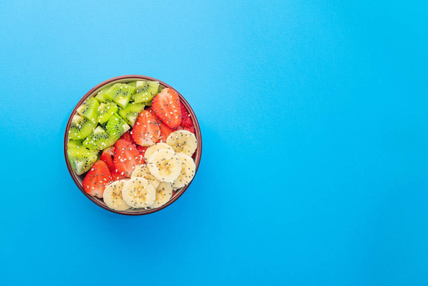 Salada de frutas frescas em um fundo azul. Vista superior. Copyspace para texto. - Foto, Imagem