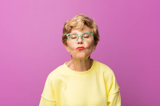 old pretty woman pressing lips together with a cute, fun, happy, lovely expression, sending a kiss - Foto, immagini