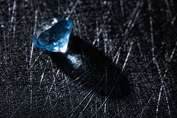 Κοντινή φωτογραφία του μπλε φυσικό διαμάντι πέτρα σε μαύρο φόντο. εργασίες κοσμηματοποιίας, εισαγωγή πέτρας. - Φωτογραφία, εικόνα