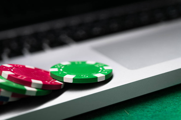 Гра в покер онлайн з ноутбуком на зеленому фоновому столі
. - Фото, зображення