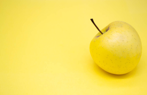 Yellow large Golden Apple on the right side on a yellow background. Copy space. - Φωτογραφία, εικόνα