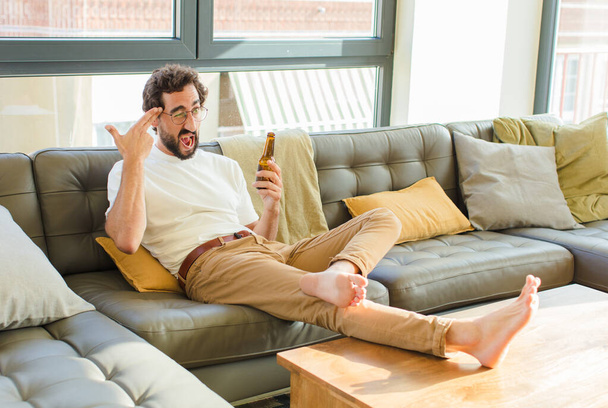 young bearded cool man sitting on a couch at home - Foto, Imagem