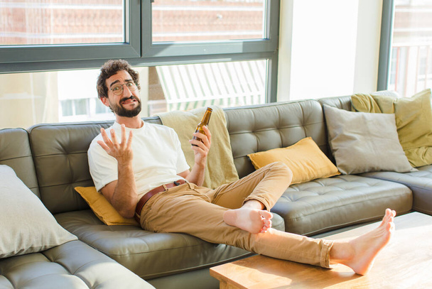 young bearded cool man sitting on a couch at home - Photo, Image