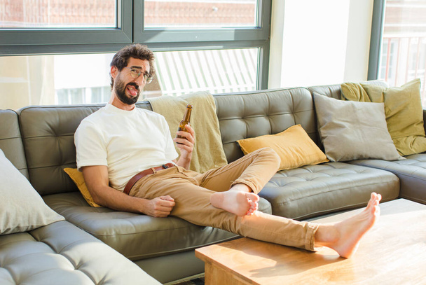 mladý vousatý cool muž sedí na gauči doma - Fotografie, Obrázek
