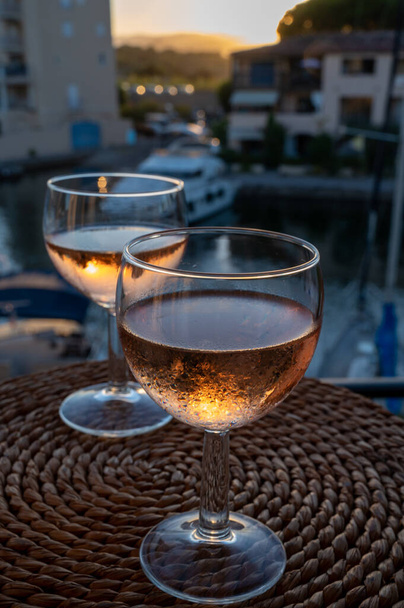 Πίνοντας από την τοπική κρύο ροζέ κρασί στο ηλιοβασίλεμα το καλοκαίρι με ιστιοφόρα καταφύγιο του Port grimaud στο παρασκήνιο, Προβηγκία, Var, Γαλλία - Φωτογραφία, εικόνα