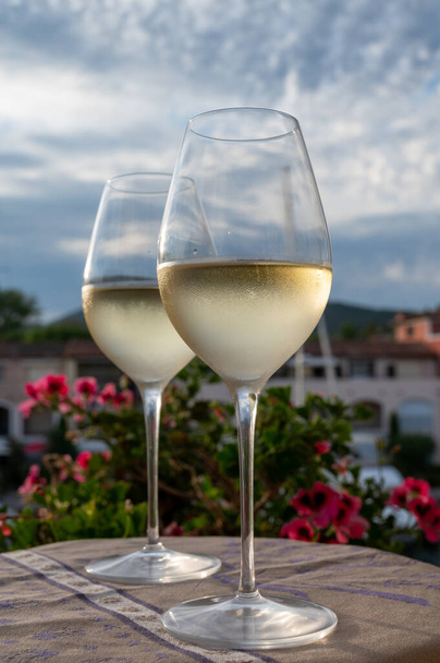 Tasting of local cold white wine in summer with sail boats haven of Port grimaud on background, Provence, Var, France - Photo, Image