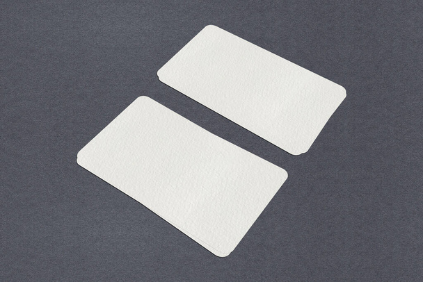 Белые стопки для макетов визитных карточек на сером бумажном фоне. - Фото, изображение