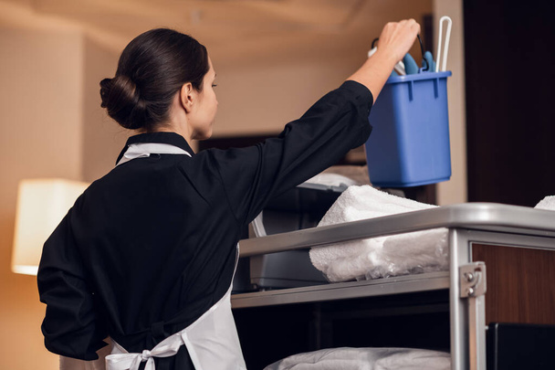 Uma dona de casa de uniforme a limpar o quarto - Foto, Imagem