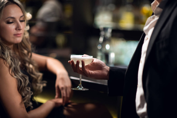 Egy férfi találkozik egy gyönyörű szőkével a bárban. - Fotó, kép
