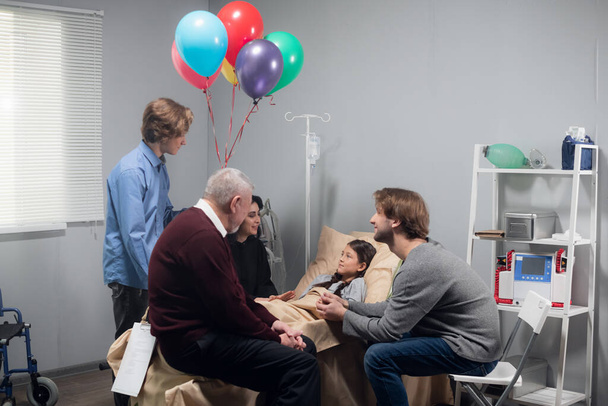 Una familia consolando a la niña durante su visita al hospital - Foto, imagen