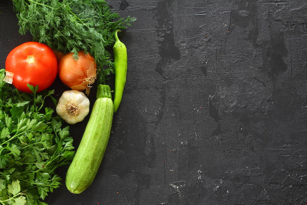 Fondo de cocina de alimentos en la mesa de piedra negra. Verduras frescas, hierbas. Ingredientes para cocinar. Vista superior con espacio de copia. - Foto, Imagen