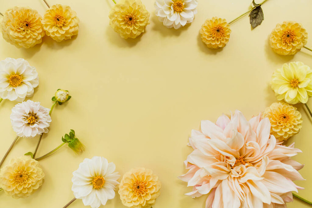 Orange, white, flowers dahlias on yellow pastel background. Flowers composition. Flat lay, top view, copy space. Summer, autumn concept. - Fotografie, Obrázek