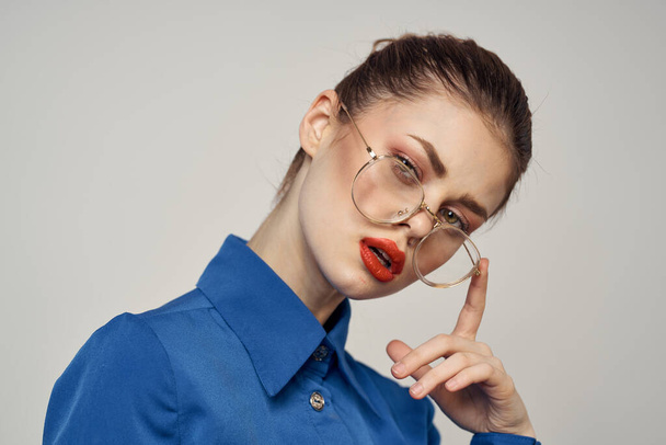 Portrait of emotional woman in blue shirt and glasses bright makeup model light background cropped view Copy Space - Foto, Bild