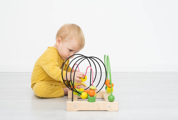 Küçük sarışın çocuk eğitici bir oyuncakla oynuyor.. - Fotoğraf, Görsel
