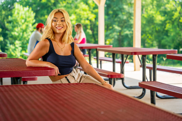 Ein hinreißendes junges blondes Model genießt einen Tag im Freien, während es während der Covid-19-Pandemie einen sicheren Abstand zu anderen hält - Foto, Bild