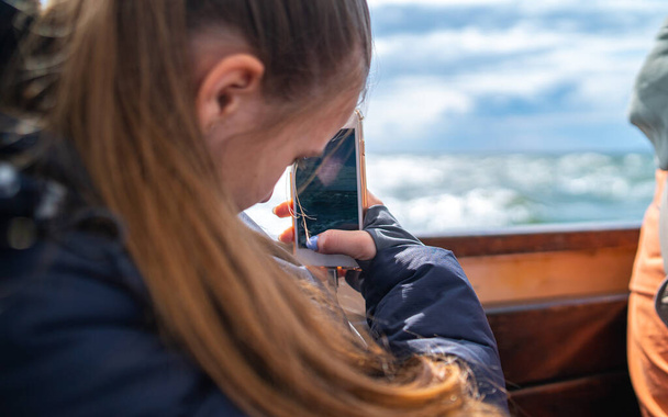 Μακρυμάλλης κορίτσι κάνει μια φωτογραφία με το smartphone - Φωτογραφία, εικόνα