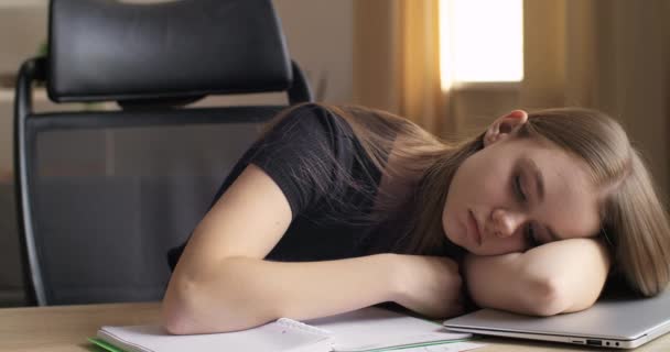 Yakın çekim, çok çalışan güzel bayan öğrenci kız iş yerinde dizüstü bilgisayarla uyuyakaldı. Motivasyonsuz ofis çalışanı masada yatar can sıkıntısı hisseder, dinlenir, uykusuzluk çeker. - Video, Çekim