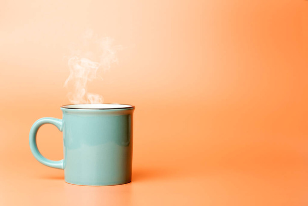 Cup minimal concept. Cup with hot coffee or tea on a blank colored background. - Photo, Image