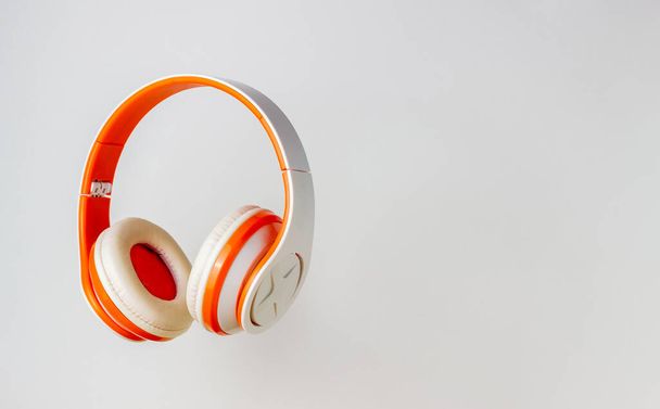 Orange headphones on a white background. Minimal concept. Mock-up. Music. Levitation - Φωτογραφία, εικόνα