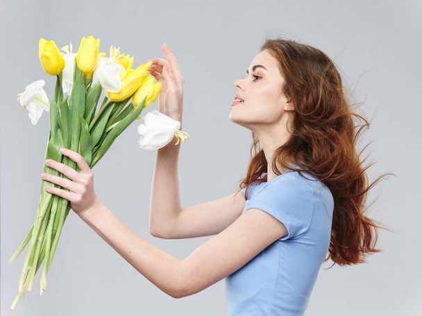 Woman with bouquet of flowers holidays spring gray background  - 写真・画像