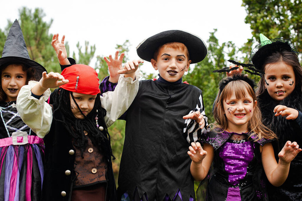Портрет детей в костюмах к Хэллоуину на фоне деревьев крупным планом - Фото, изображение