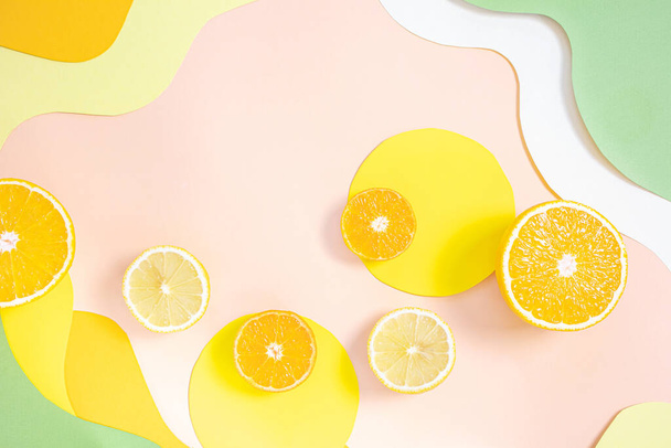 Halved lemons, oranges, tangerines on vibrant colored wave backgrounds. Paper art style on photo. Concept of citrus, vitamin C, fruit. - Photo, Image