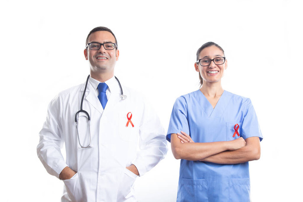 Medico e infermiere con nastro rosso AIDS su sfondo bianco. Concetto di Giornata mondiale dell'AIDS. - Foto, immagini