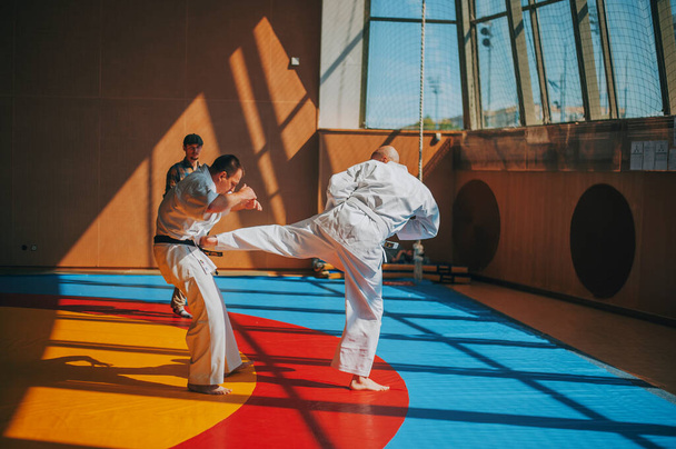 Kopasz ember kemény ütések ellenfél tatami - Fotó, kép