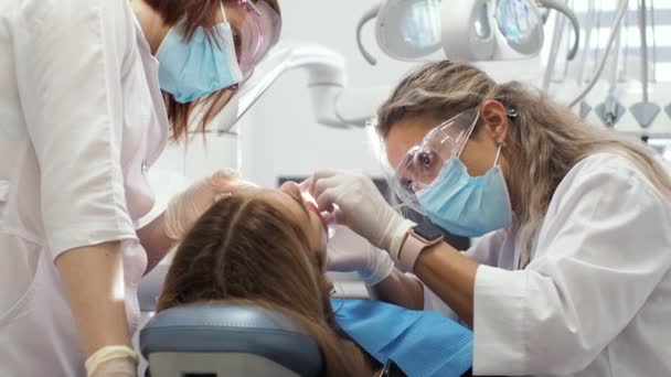 Mujer joven dentista Recepción en el ortodoncista Sustitución de los aparatos ortopédicos Puliendo la unión del gel - Imágenes, Vídeo