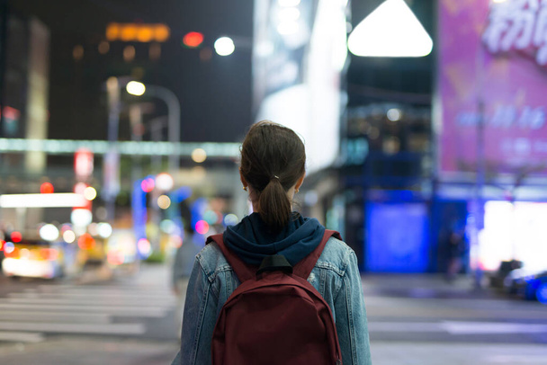 Femme marche à travers la ville de nuit. La vue de l'arrière. - Photo, image