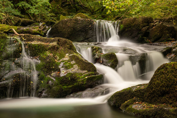Long exposure of a waterfall on the Hoar Oak Water river at Watersmeet in Exmoor National Park - Photo, Image