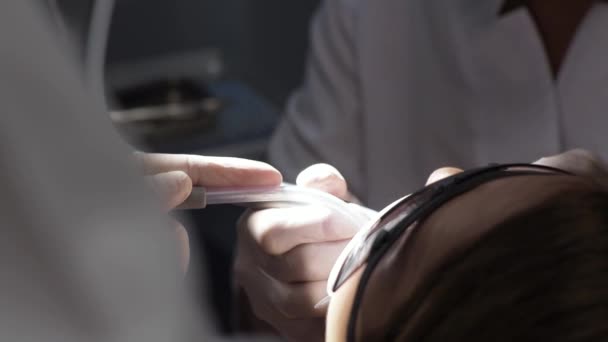 Νεαρή γυναίκα οδοντίατρος Υποδοχή στην ορθοδοντική Αντικατάσταση σιδεράκια στίλβωση Gel συγκόλληση - Πλάνα, βίντεο