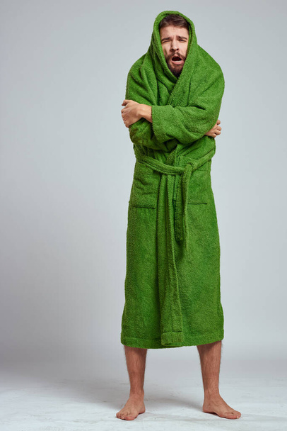 емоційний чоловік в зеленому халаті на світлому тлі в моделі повного росту веселих емоцій
 - Фото, зображення