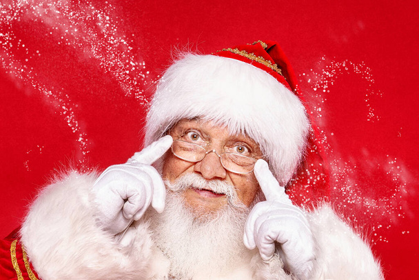 Jolly Santa Claus smiling over festive red background. Merry Christmas and Happy New Year! - 写真・画像
