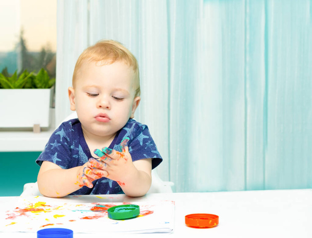 Suloinen pieni poika maalaamassa sormilla. Luovat pelit lapsille. Varhaisen kehityksen käsite - Valokuva, kuva
