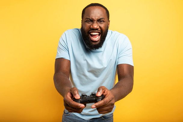 Boldog ember játszik egy videojáték a piros háttér - Fotó, kép