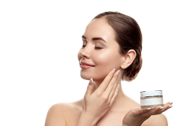 Beautiful Woman holdinging  moisturizing cream . Cosmetics. Portrait of female with clean  skin. Skin Care. Facial treatment. Cosmetology, beauty and spa - Фото, зображення