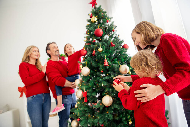 Photo of full big family five people gathering three small kids dad hold daughter boy take ball decorate x-mas tree toys baubles star wear red jumper jeans in home living room indoors - Photo, Image
